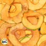 اسلایس‌های هلالی شکل خربزه جانان خشک با رنگ نارنجی روشن و لبه‌های سبز نازک که روی هم قرار گرفته‌اند.