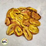 اسلایس‌های حلقه‌ای انجیر سیاه خشک با پوست تیره و گوشت روشن‌تر که روی سطحی خاکستری قرار گرفته‌اند.