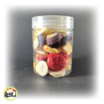 ظرف شیشه‌ای شفاف پر از مخلوط میوه خشک انجمادی رنگارنگ شامل توت فرنگی، موز، سیب و کیوی.