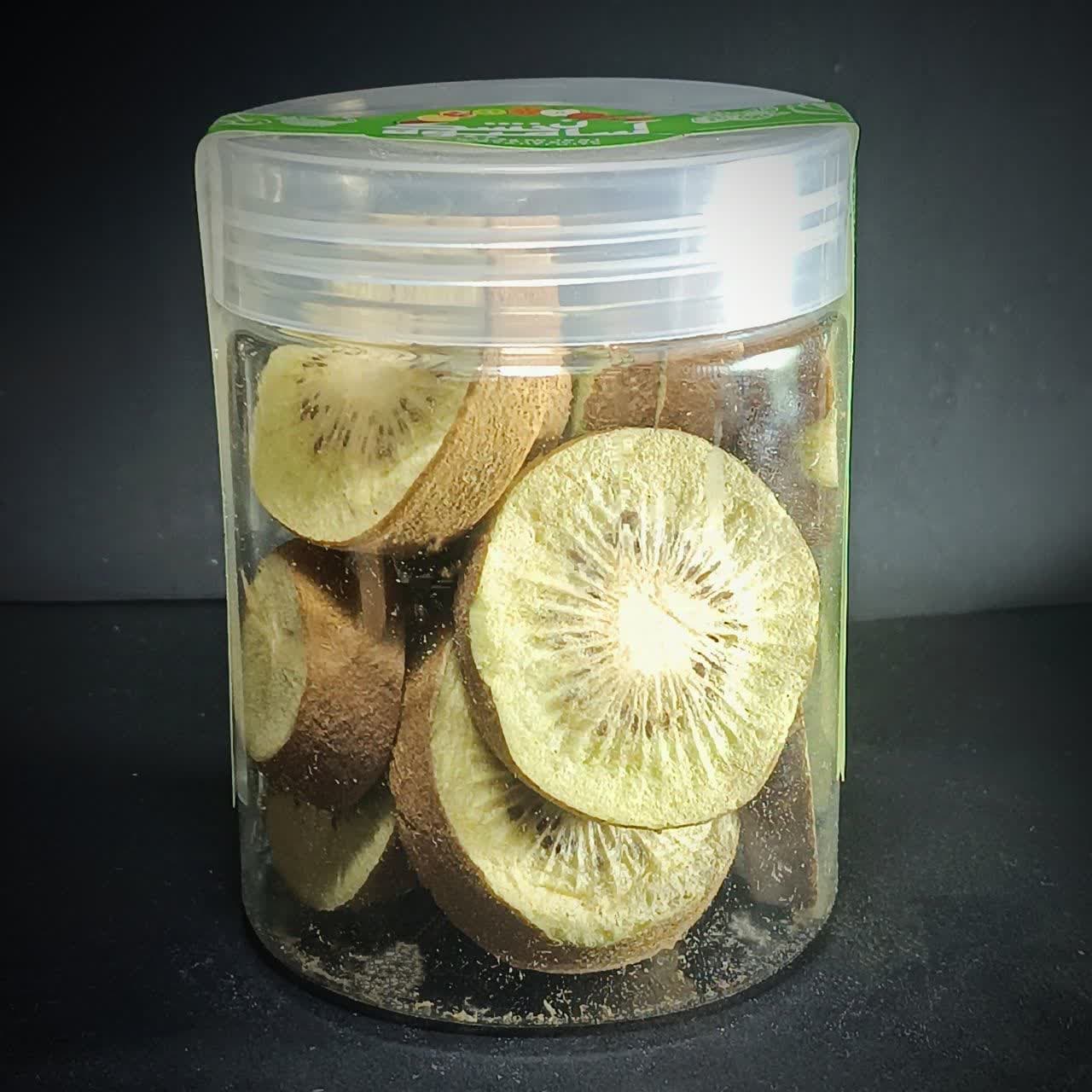 اسلایسهای کیوی خشک انجمادی با پوست که در یک ظرف شیشهای شفاف قرار دارند. اسلایسهای کیوی خشک انجمادی با پوست که در یک ظرف شیشهای شفاف قرار دارند.